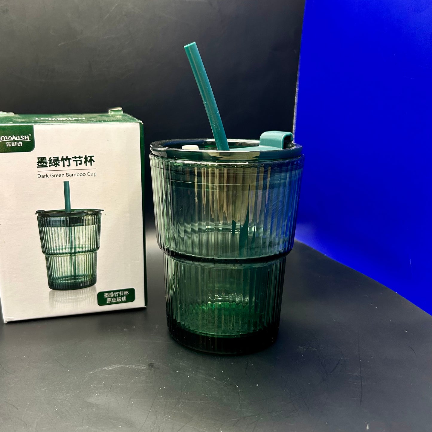 Gobelet en verre cannelé de couleur verte avec un couvercle et une paille.