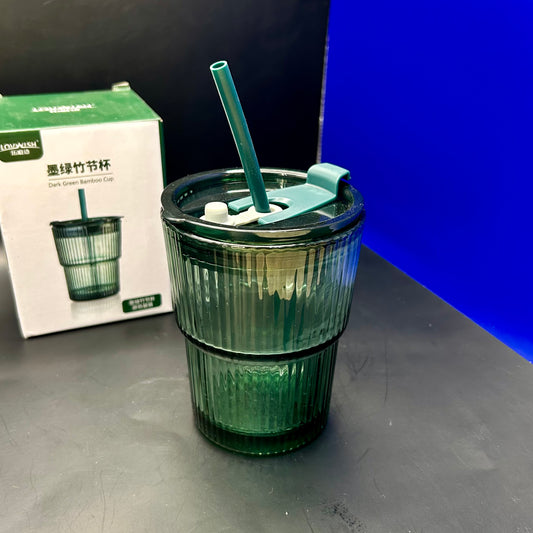 Gobelet en verre cannelé de couleur verte avec un couvercle et une paille.